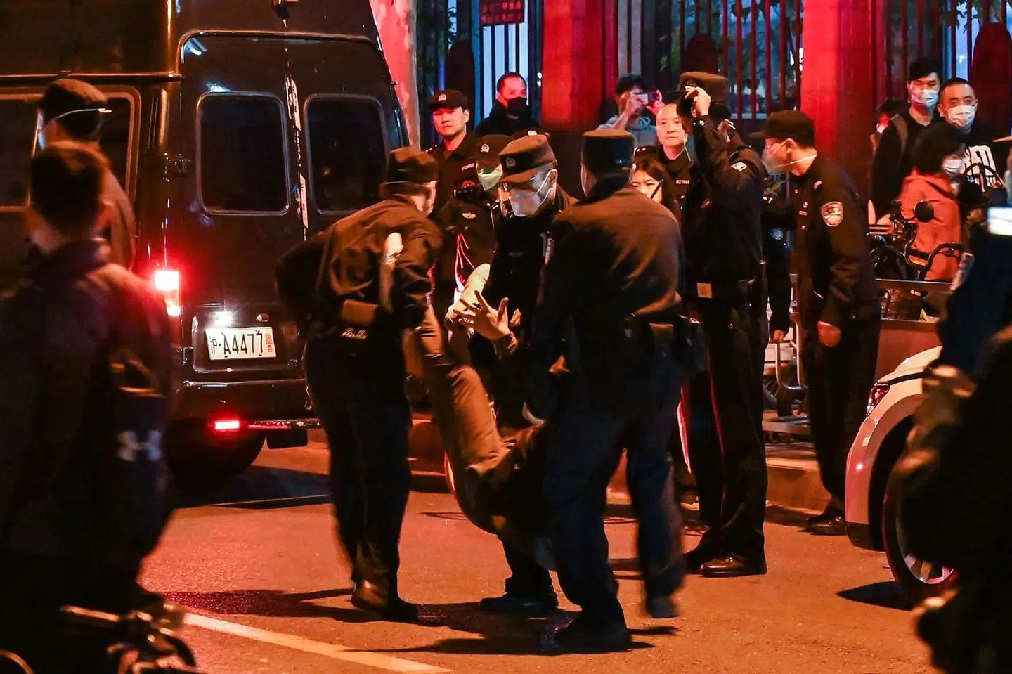TOPSHOT - A man is arrested while people gathering on a street in Shanghai on November 27, 2022, where protests against China's zero-Covid policy took place the night before following a deadly fire in Urumqi, the capital of the Xinjiang region. (Photo by Hector RETAMAL / AFP)