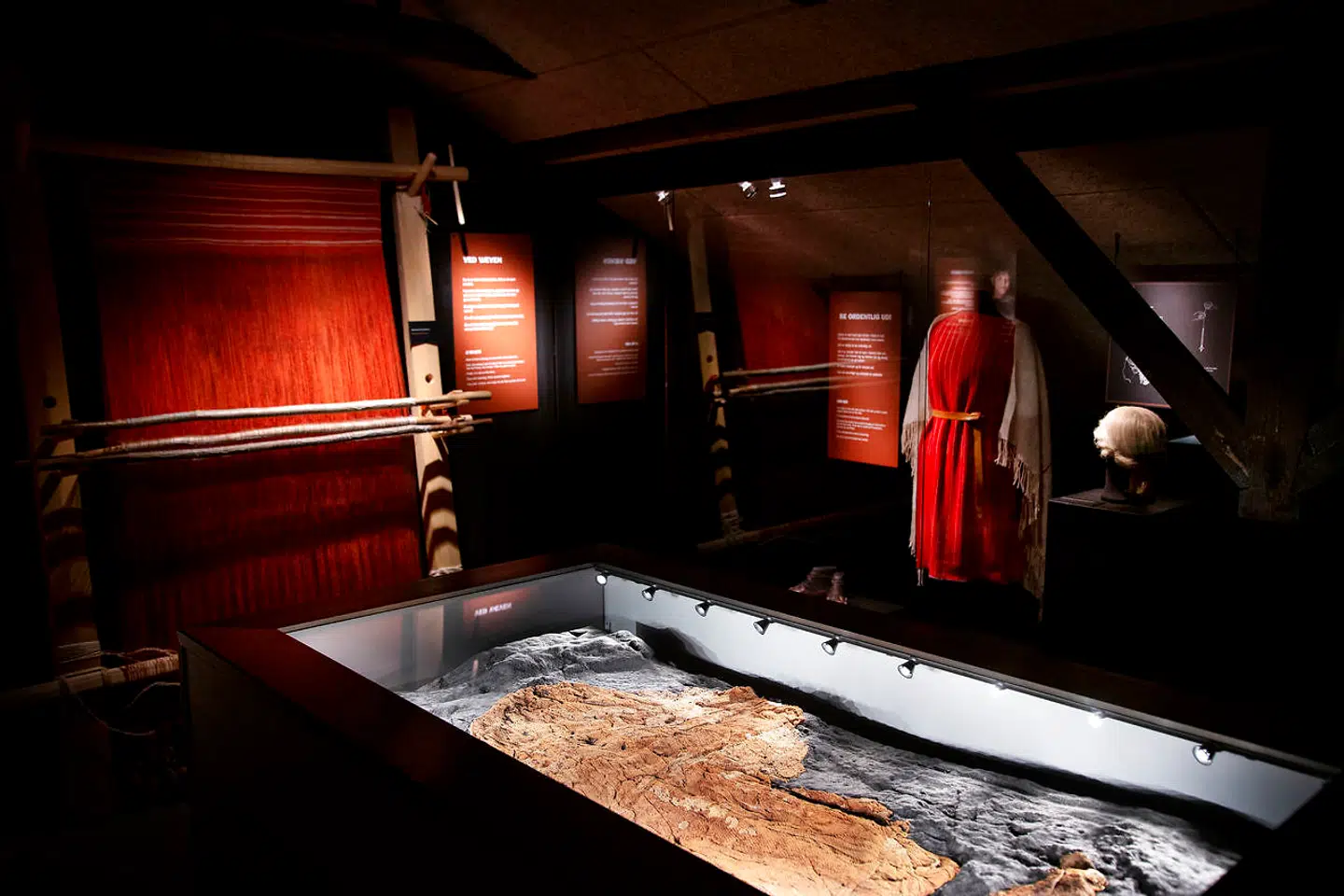 I 1993 gjorde arkæologer på Museum Midtjylland et sensationelt gravfund i Hammerum tæt ved Herning. I en af gravene fandt man usædvanligt velbevarede tekstiler, formentlig fra en kvinde, som er blevet døbt Hammerum-pigen. På billedet ses i forgrunden udgravningen og bag den en rekonstruktion af tøjet, som kan ses på Klosterlund Museum i Engesvang.