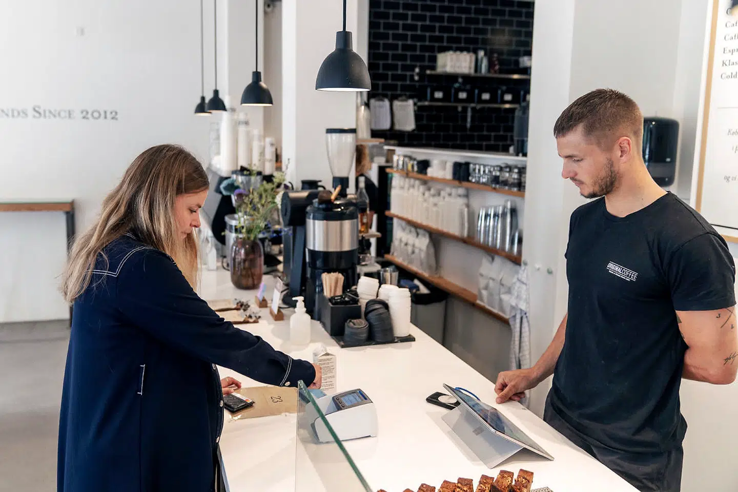 En kunde betaler kontantløst på Original Coffee ved Sortedam Dossering i København.