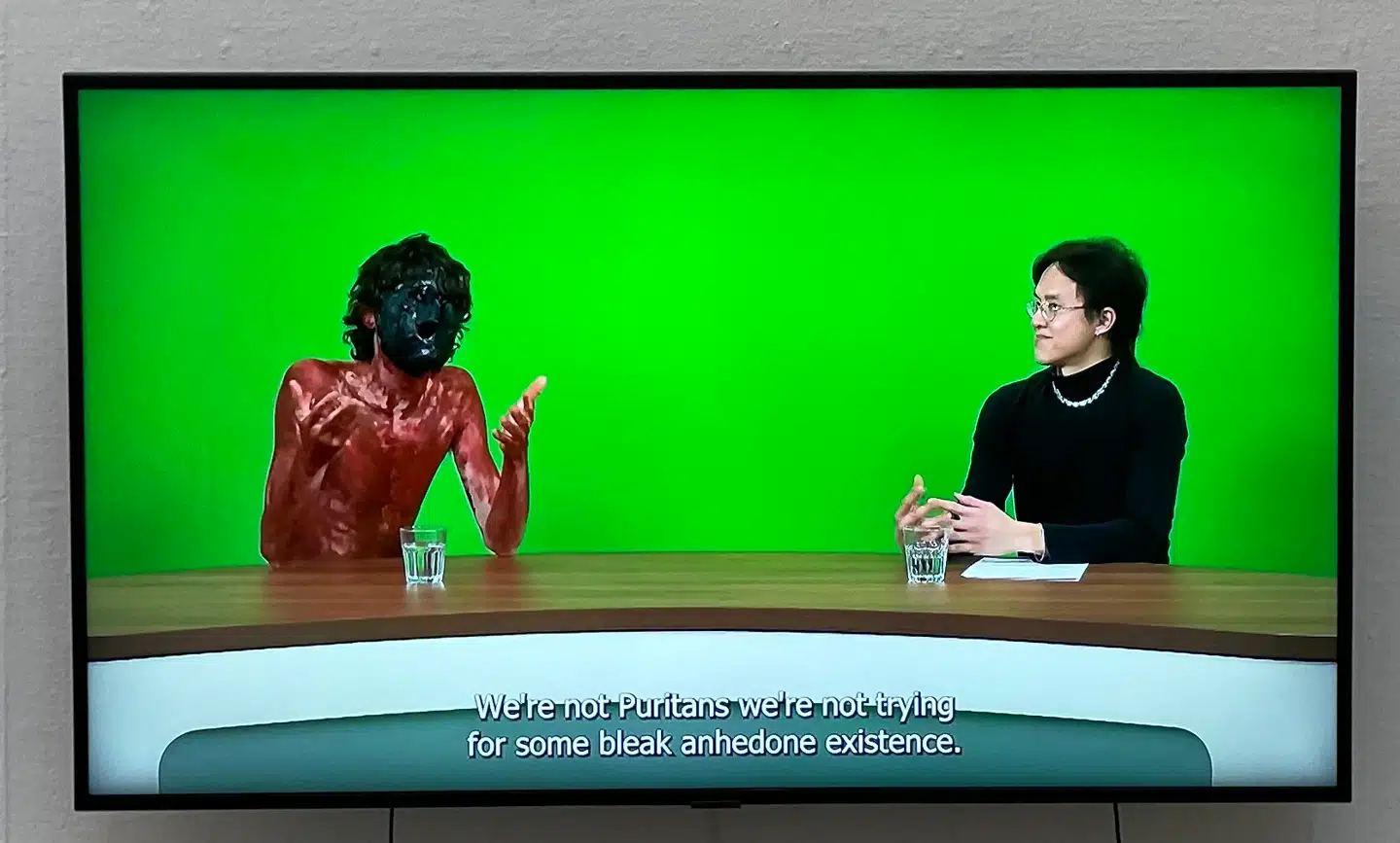 Thor Tao Hansens værk »Tonight with Zachary Khan«. Den Fries efterårsudstilling 2022. Hele konceptet mindede foruroligende meget om Casper Christensen kult comedy-program fra 1999, »Casper & Mandrilaftalen«.