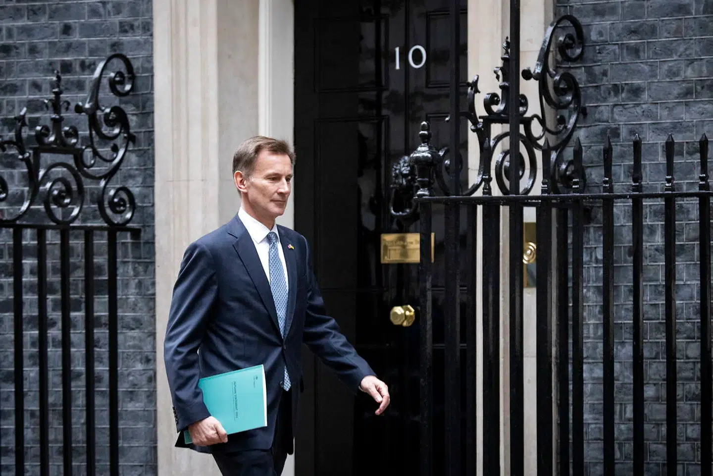 Den britiske finansminister, Jeremy Hunt, passerer Downing Street 10 med sin »autum statement« – Storbritanniens svar på finansloven – under armen på vej for at præsentere den i det britiske parlament, House of Commons. Foto: Tolga Akmen/AFP/Ritzau Scanpix
