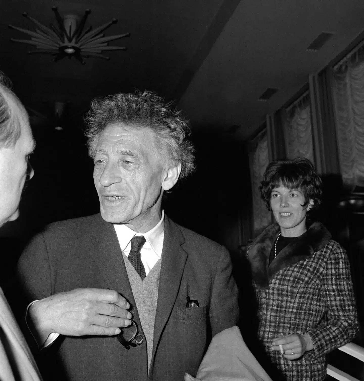 Kunstneren Alberto Giacometti (1901-1966) blev født i Schweiz, hvor han fik sin kunstneriske uddannelse. Allerede i 1922 flyttede han til Paris, hvor han boede og arbejdede i over 40 år. Her er han i 1965 fotograferet med sin hustru, Annette, da parret kom hjem fra en rejse til USA.