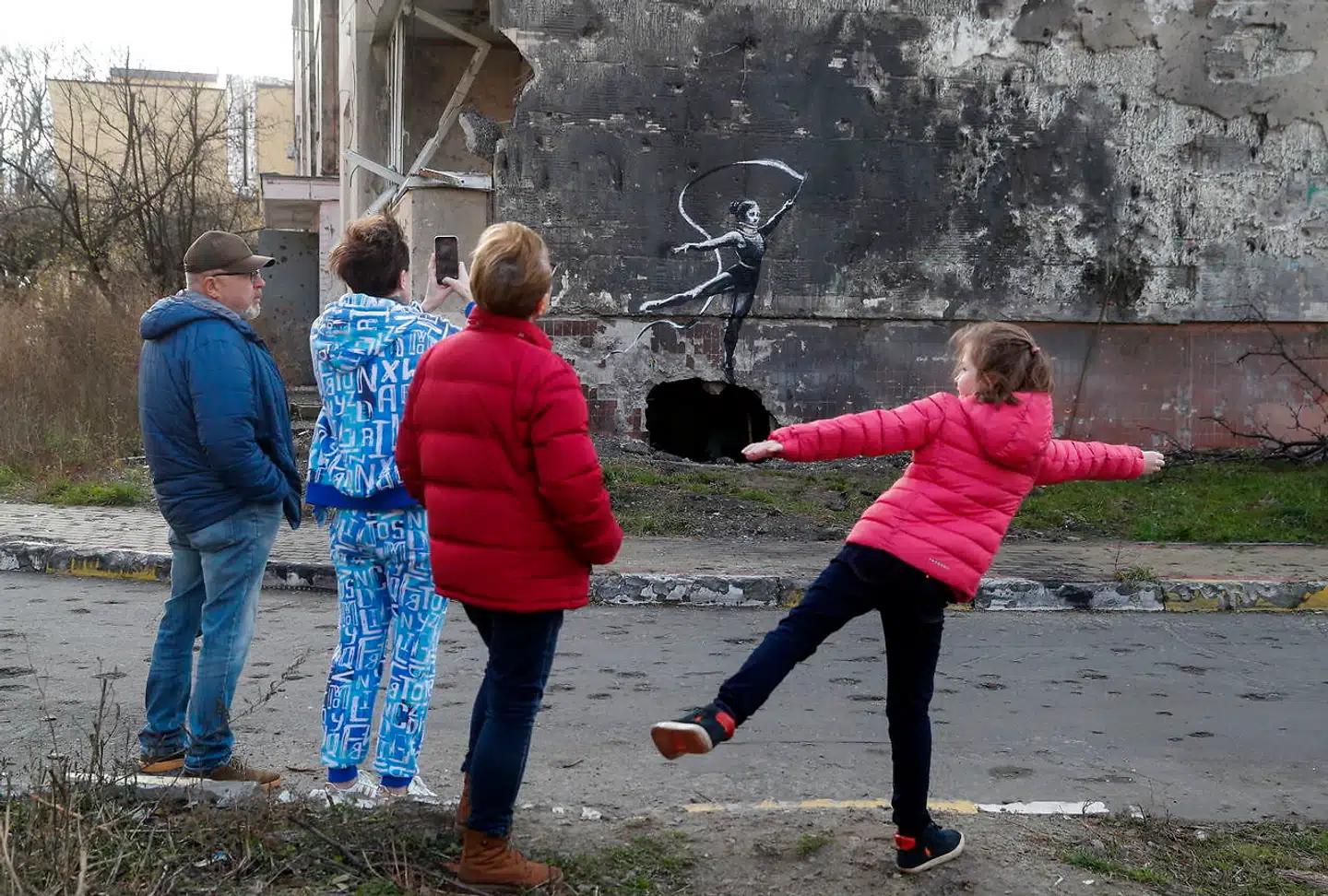 Et af Banksys billeder viser en kvindelig gymnast med vimpel. Graffitien er malet på en af de mange bygninger i byen Borodjanka, som russerne har bombet.