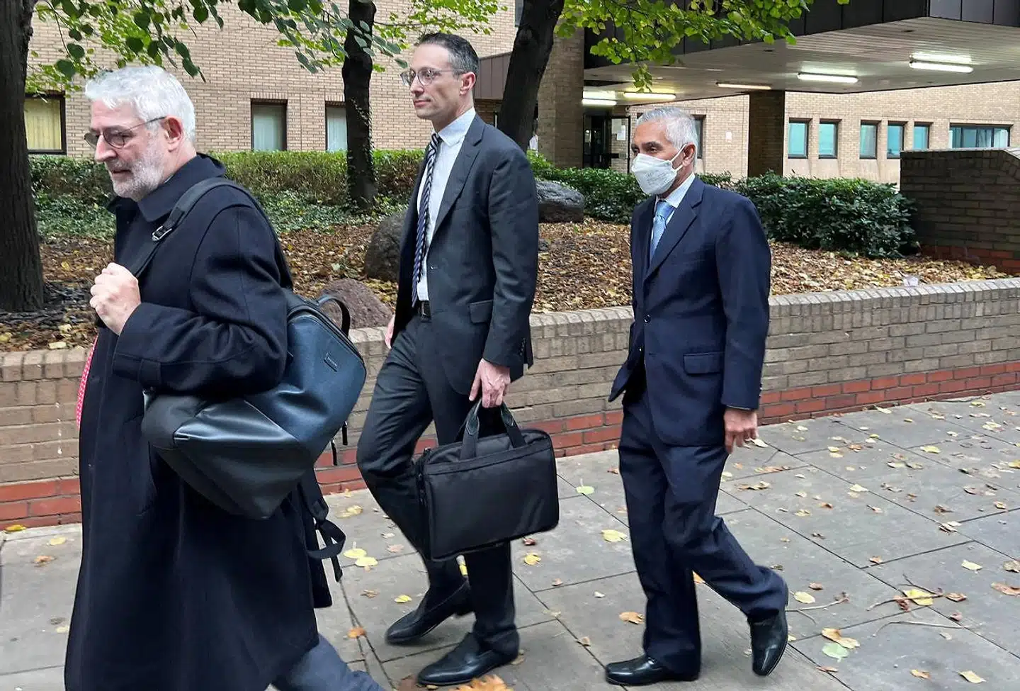Bestyrelsesformand Kalidas Madhavpeddi (til højre) forlader en af retshøringerne i Southwark Crown Court i London onsdag, hvor detaljerede afsløringer af omfattende bestikkelse er kommet frem. Torsdag ventes der at falde dom.