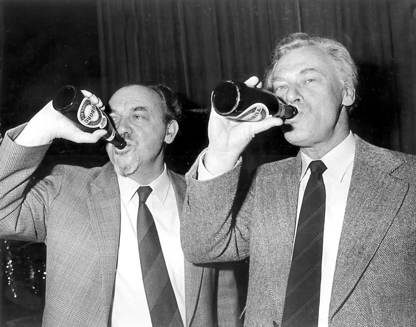 Folkelig var han, Anker Jørgensen. Her sammen med den konservative statsminister Poul Schlüter, mens de to nyder en pilsner under et valgmøde.