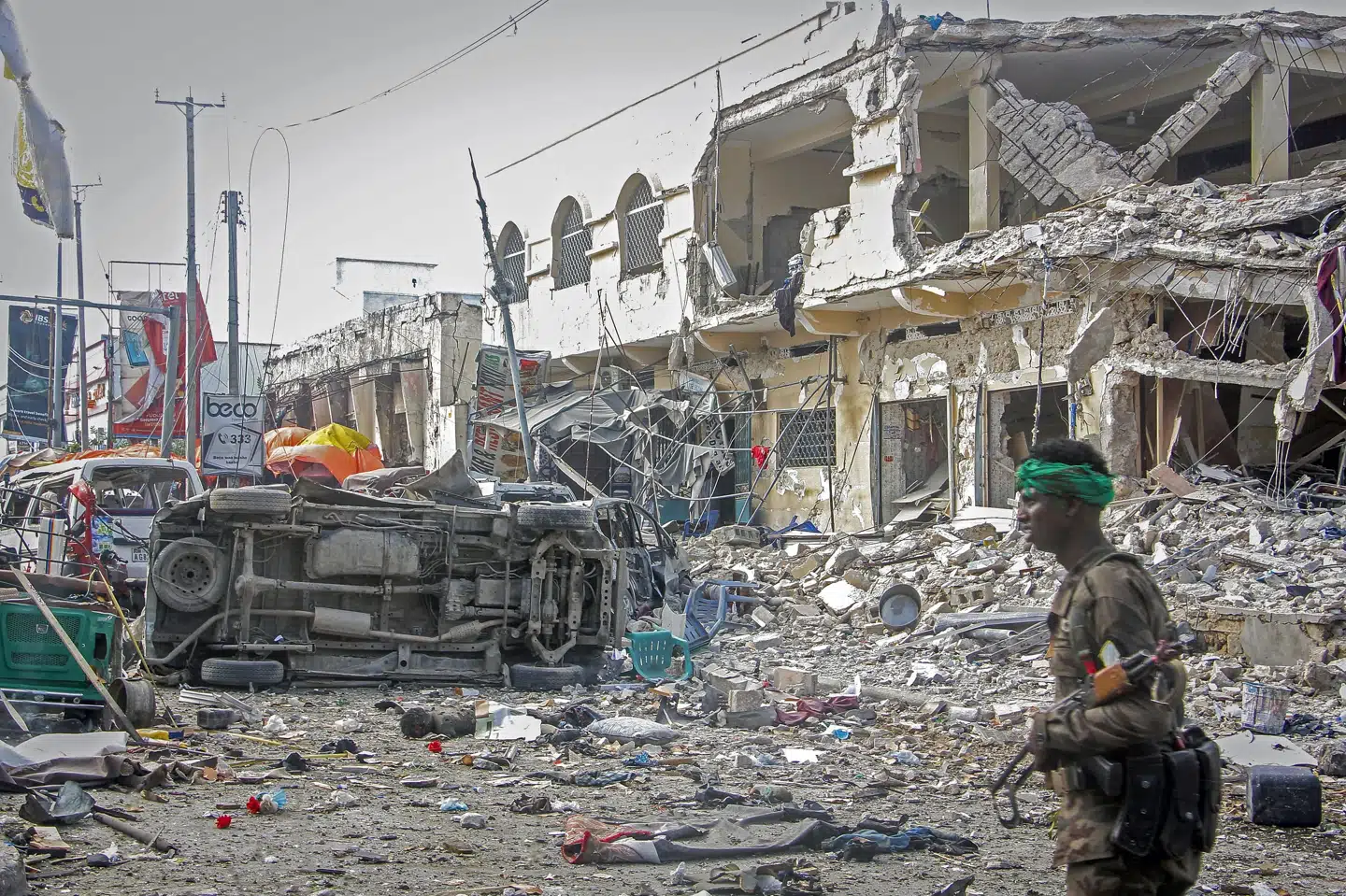 En somalisk soldat går forbi stedet, hvor to bilbomber eksploderede og dræbte mindst 100 personer i hovedstaden Mogadishu. Farah Abdi Warsameh/Ritzau Scanpix
