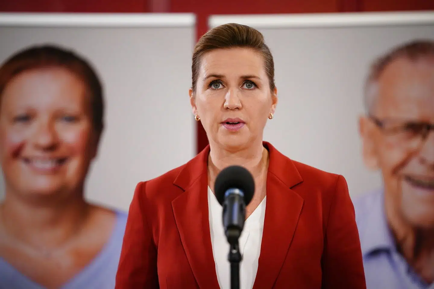 Statsminister Mette Frederiksen (S) vil ikke pege på, hvem der skal have mere i løn – men til onsdagens pressemøde var hun flankeret af store billeder med sosu-medarbejdere.