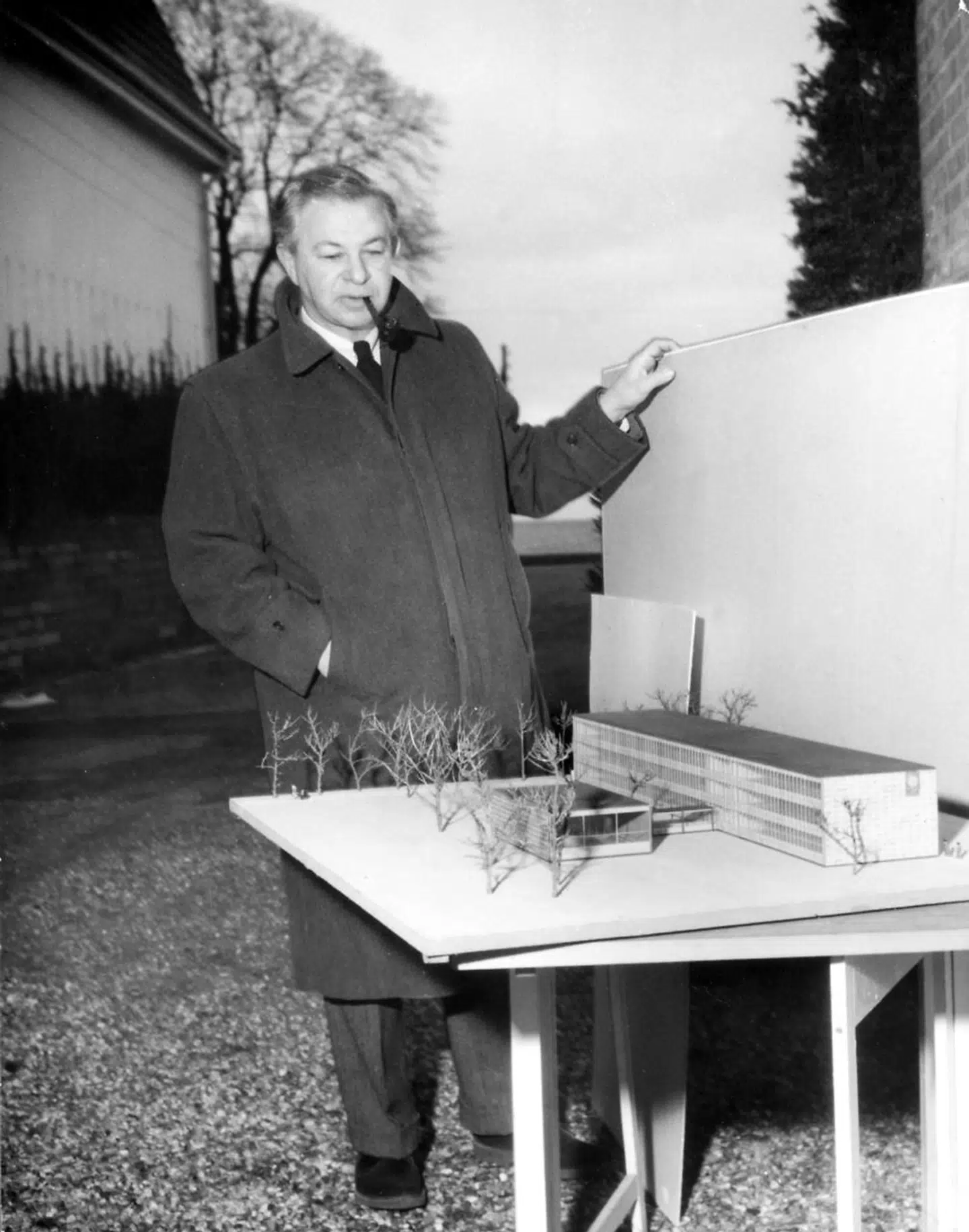 »Jeg har den idiosynkrasi, at jeg ikke forstår, at nogen tager Arne Jacobsen alvorligt. Han har diskvalificeret sig selv ved at designe så meget bestik, der ikke egner sig til at sønderdele mad eller føre den fra bordet op til munden,« siger Henrik Dahl. Foto: Arkitekt Arne Jacobsen med model af Rødovre Rådhus. Udateret arkivbillede cirka 1954.