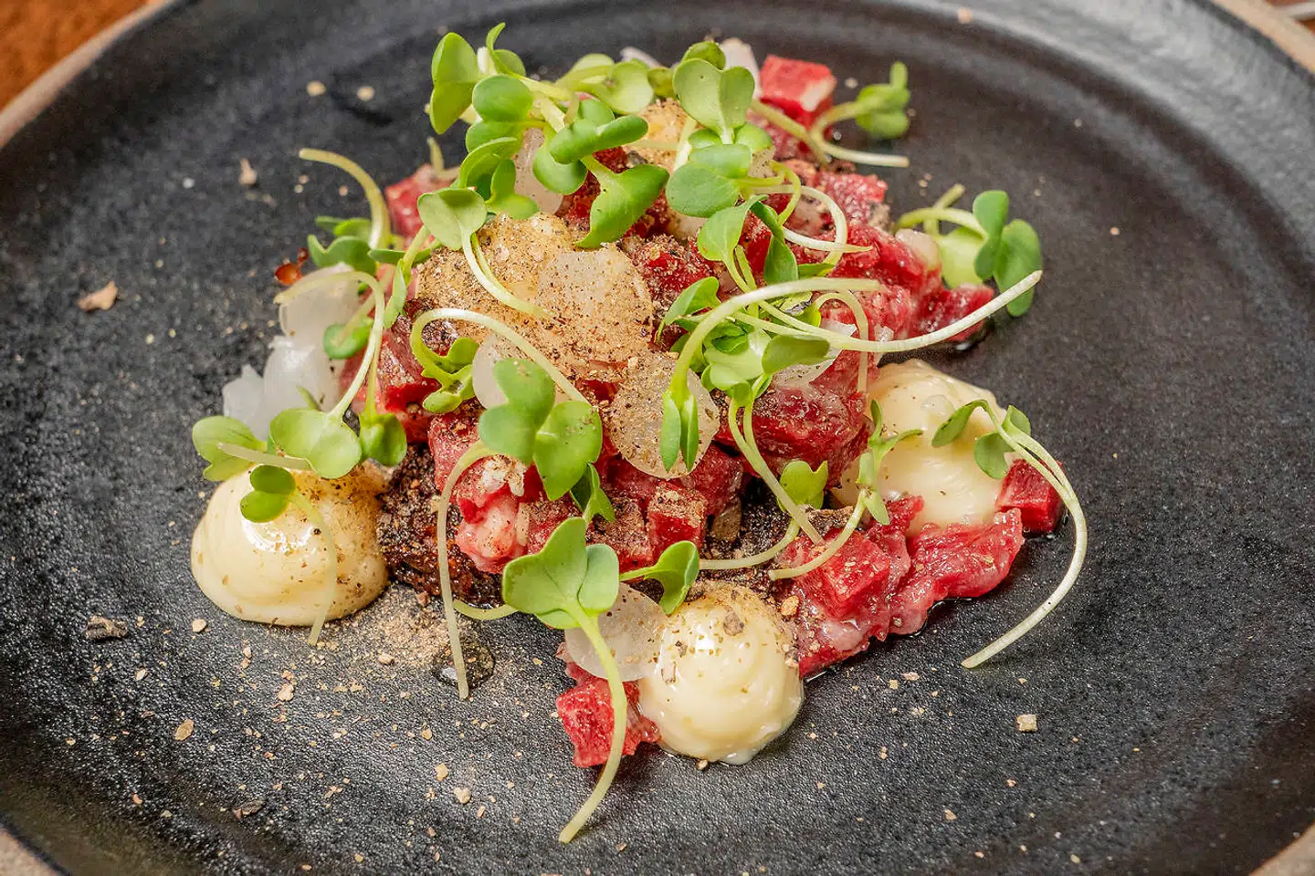 Håndskåret oksetatar med syltede bøgehatte og perleløg.