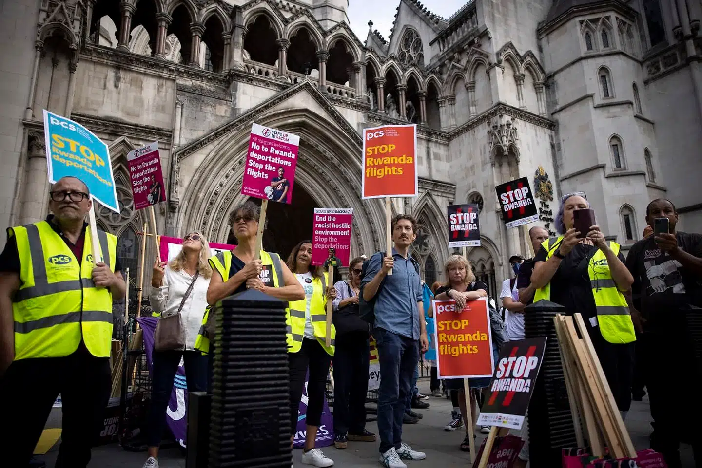 Foran The Royal Courts of Justice i det centrale London protesterer folk mod den britiske regerings idé om at sende asylansøgere til Rwanda på en enkeltbillet. Samme ambition har den danske regering, og dermed kan den britiske retssag også få betydning for dansk udlændingepolitik.