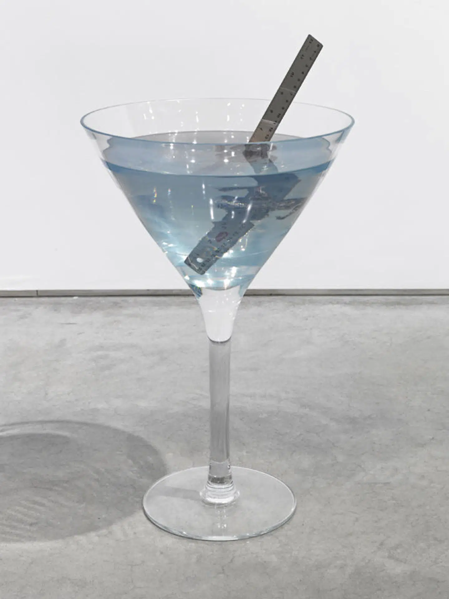 Et nærskud af et af Nina Beiers forvoksede cocktailglas fra serie »Punge« med objekter fanget i epoxy. Objekterne har hun fundet blandt det væld af fotografier, der bliver produceret til salg i diverse billedbanker, hvor absurditeten opstår i hendes sammenstillinger af for eksempel mønter på vej ud af en vandhane.