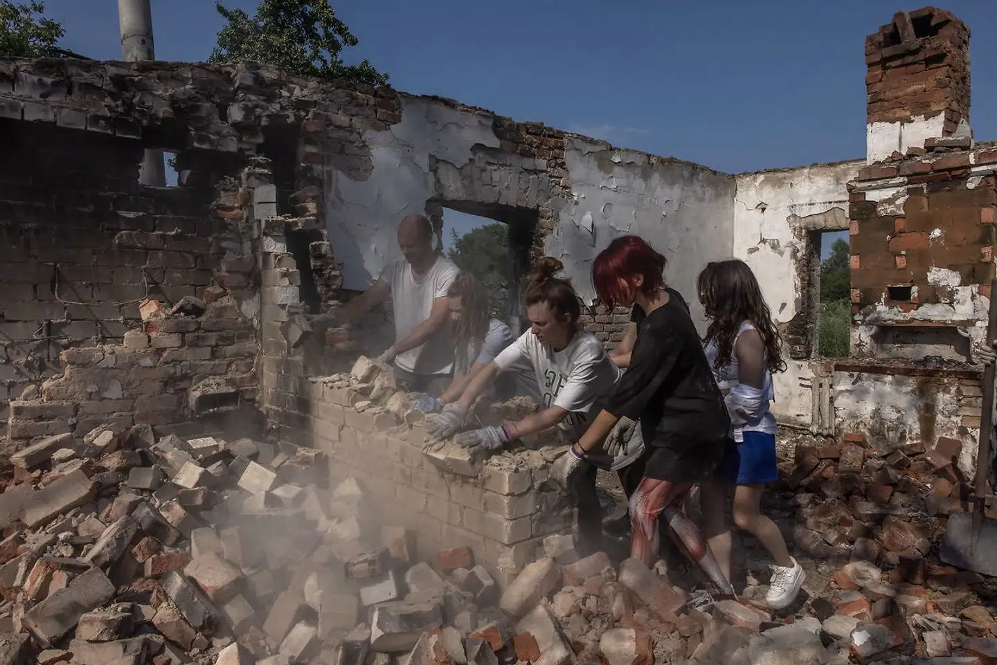 Frivillige rydder op i murbrokkerne af en ødelagt bygning i Tjernihiv-regionen, hvor danske Rockwool netop har vedtaget at igangsætte genopbygningsarbejde.