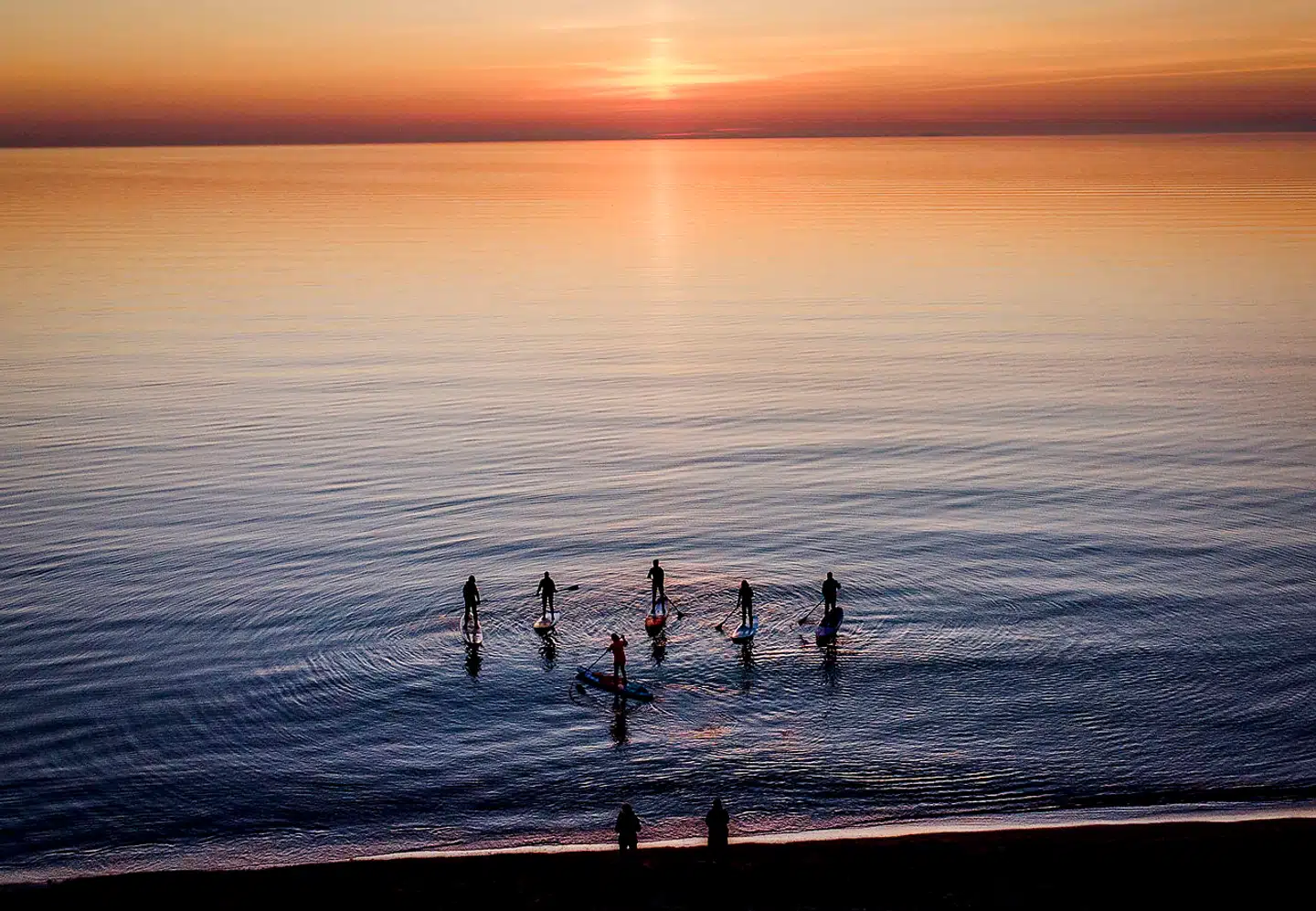 Knap nok en krusning på havoverfladen – og næsten ingen vind til vindmøllerne. Hvad sker der denne sommer? Padlere står ud på Østersøen fra det nordlige Tyskland.