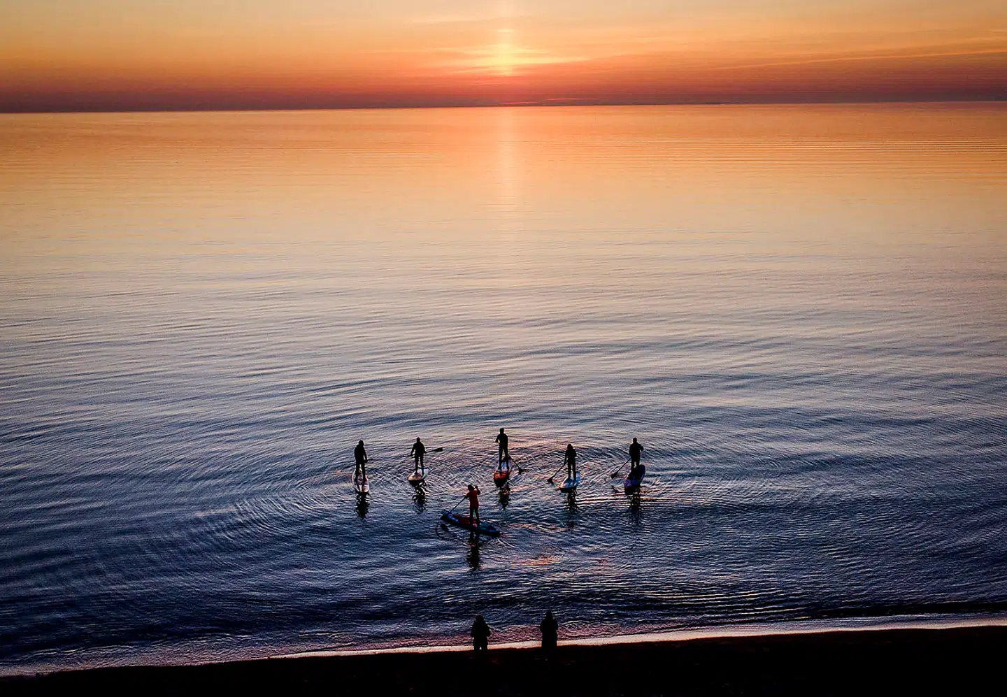 Knap nok en krusning på havoverfladen – og næsten ingen vind til vindmøllerne. Hvad sker der denne sommer? Padlere står ud på Østersøen fra det nordlige Tyskland.