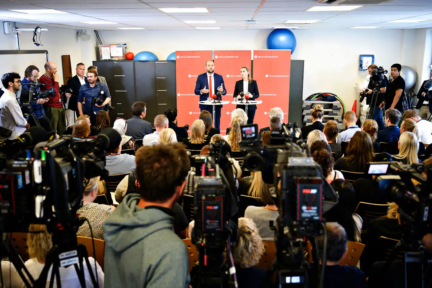 På SOSU-uddannelsescenteret i Herlev fremlagde Mette Frederiksen i maj 2019 et helt centralt punkt i Socialdemokratiets økonomiske politik: Der skulle spares tre milliarder kroner på konsulenter i det offentlige. Der var nemlig kommet for mange mennesker i det offentlige, der »analyserer, evaluerer, implementerer, forankrer og alle de der fine ord«. Ifølge Mette Frederiksen var konsulenterne ikke pengene værd. I stedet skulle pengene gå direkte til »kernevelfærd«.