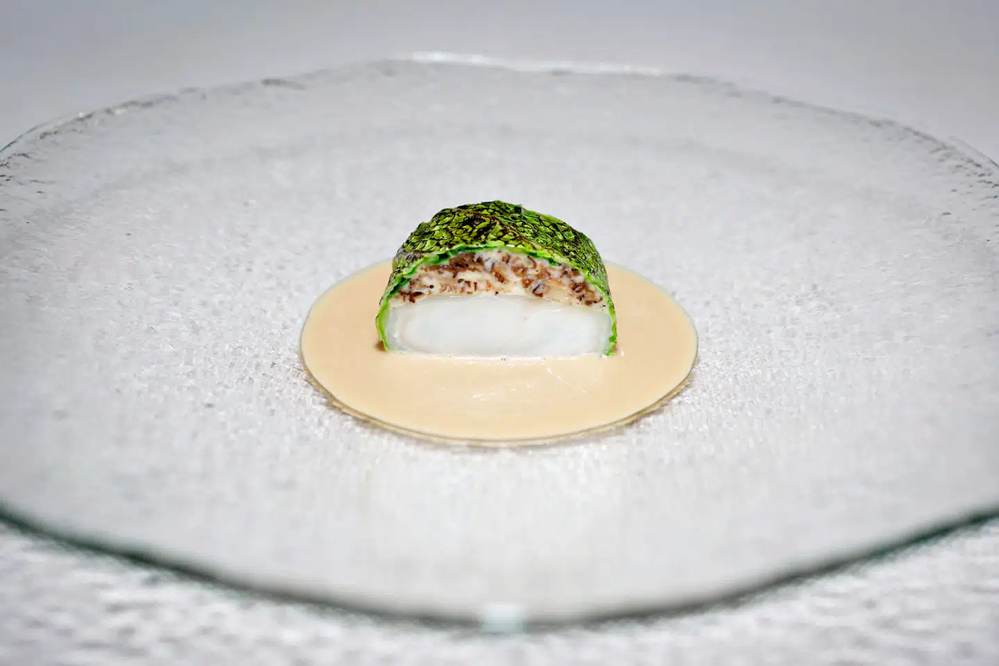 Køkkenet på restaurant Domæne i Herning er konkurrenceorienteret. Her er det dampet pighvar farseret med morkler, indpakket i grillet savoykål. Creme på morkler og creme fraiche.