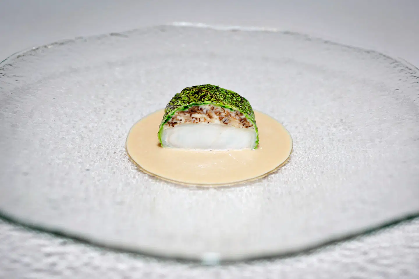 Køkkenet på restaurant Domæne i Herning er konkurrenceorienteret. Her er det dampet pighvar farseret med morkler, indpakket i grillet savoykål. Creme på morkler og creme fraiche.