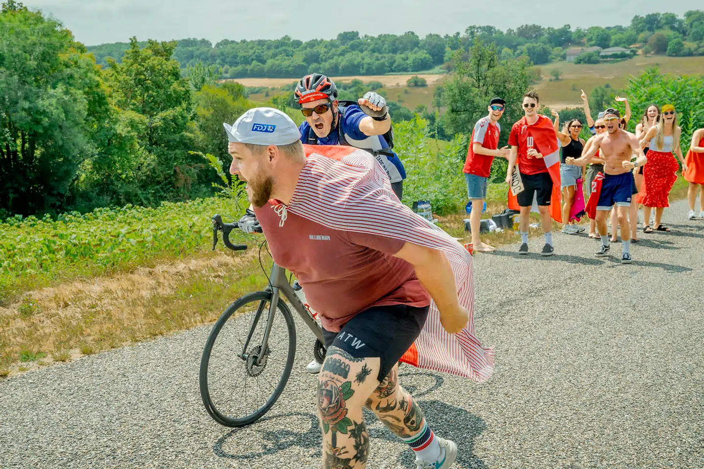 En cykelmotionist får lidt ekstra hjælp på sin rute, inden Tour de France-rytterne kører over asfalten nogle timer senere.