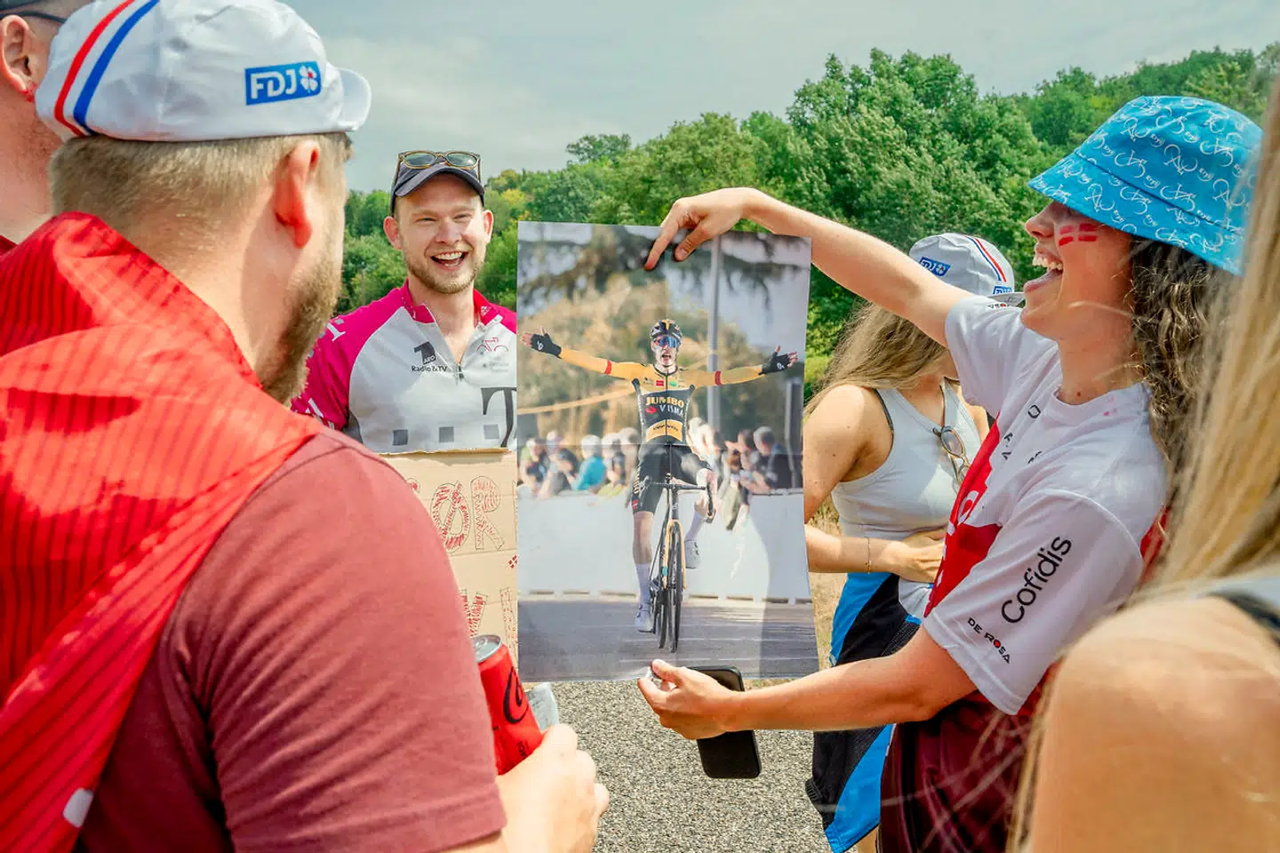 Den franske avis L'Équipe deler Jonas Vingegaard-plakater ud af vinduet, da de ser danskerne.