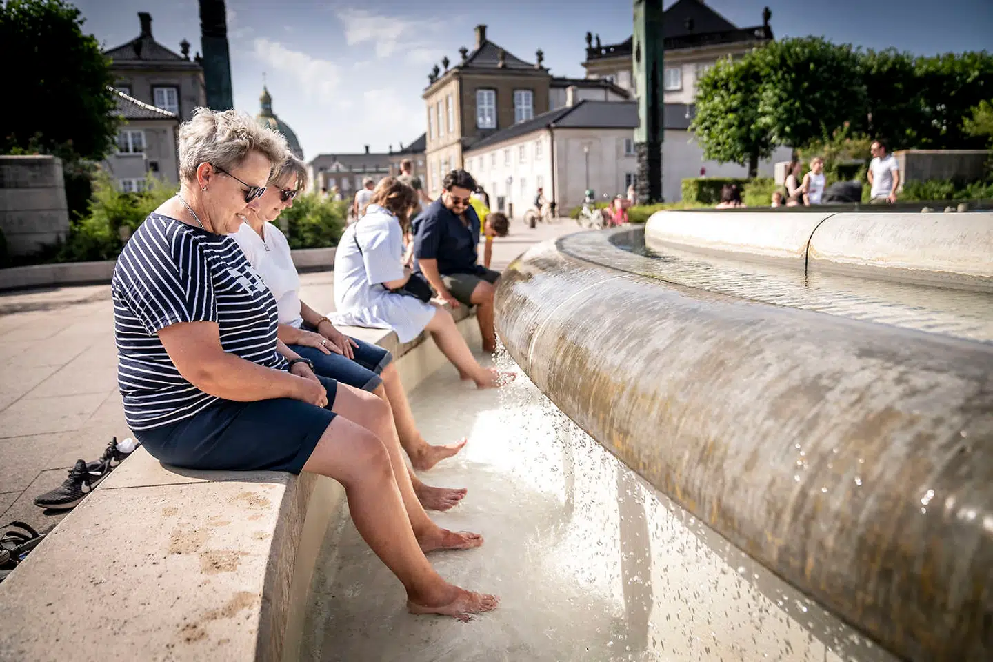 Folk dypper fødder ved springvandet i Amaliehaven i København, onsdag den 20. juli 2022. Hedebølge har ramt Danmark, hvor temperaturen forventes at komme op på 30 grader i København.. (Foto: Mads Claus Rasmussen/Ritzau Scanpix)
