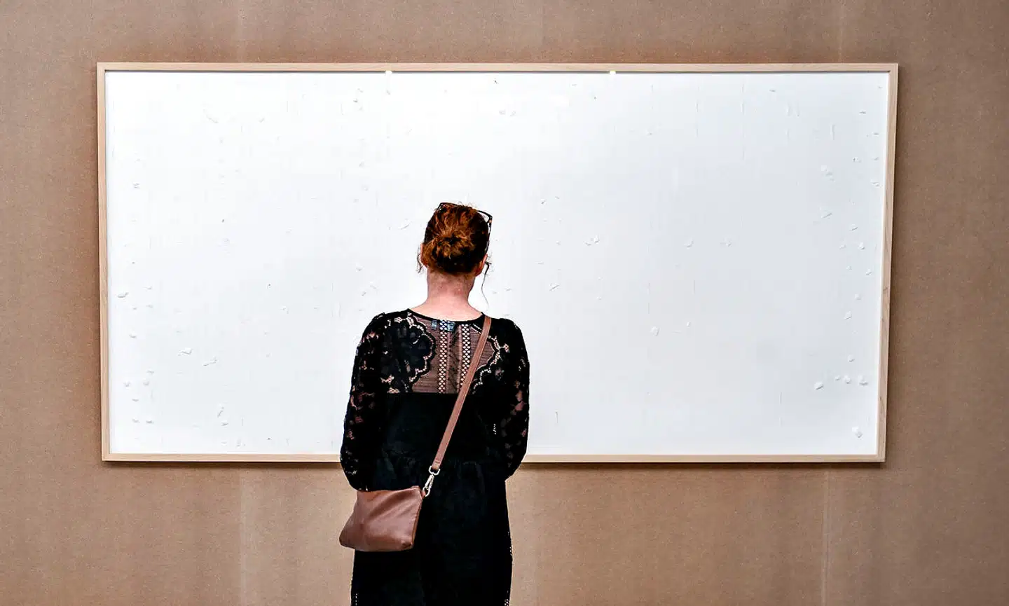 En tom billedramme, der skulle være fyldt med pengesedler for ca. 550.000 danske kroner, hænger på museet Kunsten i Aalborg, 28. september 2021. Det er kunstneren Jens Haaning, der står bag værket med titlen: "Take the Money and Run", der nu er i besiddelse af de omkring 550.000 danske kroner. Penge der skulle have befundet sig bag glasset. Beløbet i de to værker skulle svare til henholdsvis en gennemsnitlig østrigsk og dansk årsløn. Men da værkerne ankom til Kunsten i Aalborg i sidste uge og medarbejderne pakkede glasrammerne ud, var der kun tomme rammer og det tape, pengesedlerne angiveligt har hængt på. De mange penge er lagt ud som lån til kunstneren af museet. Haaning har en underskrevet kontrakt på, at pengene er i museets varetægt, når udstillingen lukker 14. januar.. (Foto: Henning Bagger/Ritzau Scanpix)