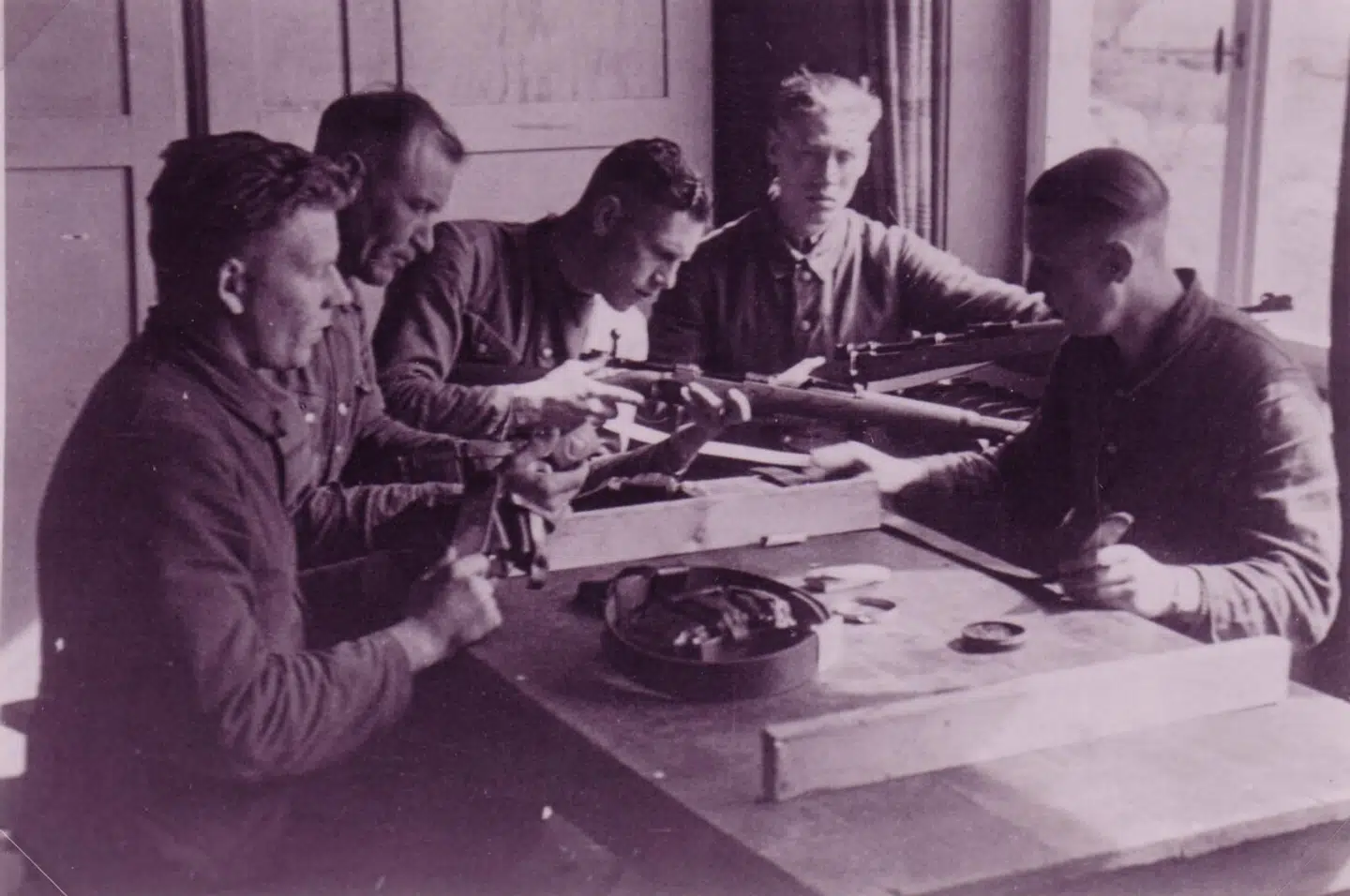 Danske medlemmer af Waffen SS med våben ved et bord på kasernen i Graz, hvor især danske, norske og hollandske frivillige i nazistisk tjeneste holdt til.