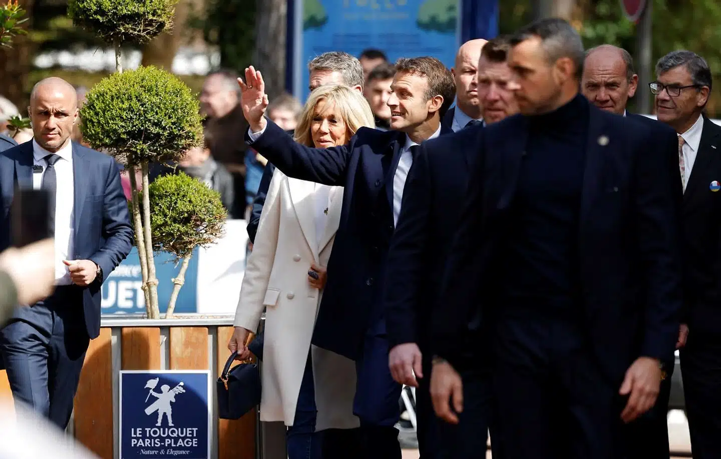 Præsident Emmanuel Macron hilser på tilhængere, da han ledsaget af sin hustru, Brigitte, over middag kom dryssende for at stemme på sit valgsted i den nordfranske badeby Le Touquet.
