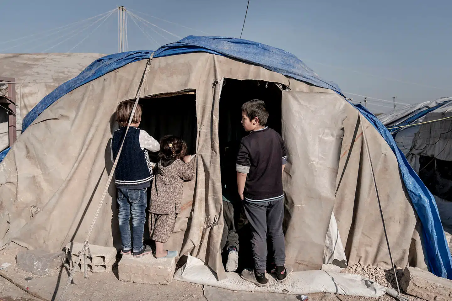 Tre børn foran en interimistisk kiosk i den kurdiske fangelejr al-Roj i det nordøstlige Syrien.