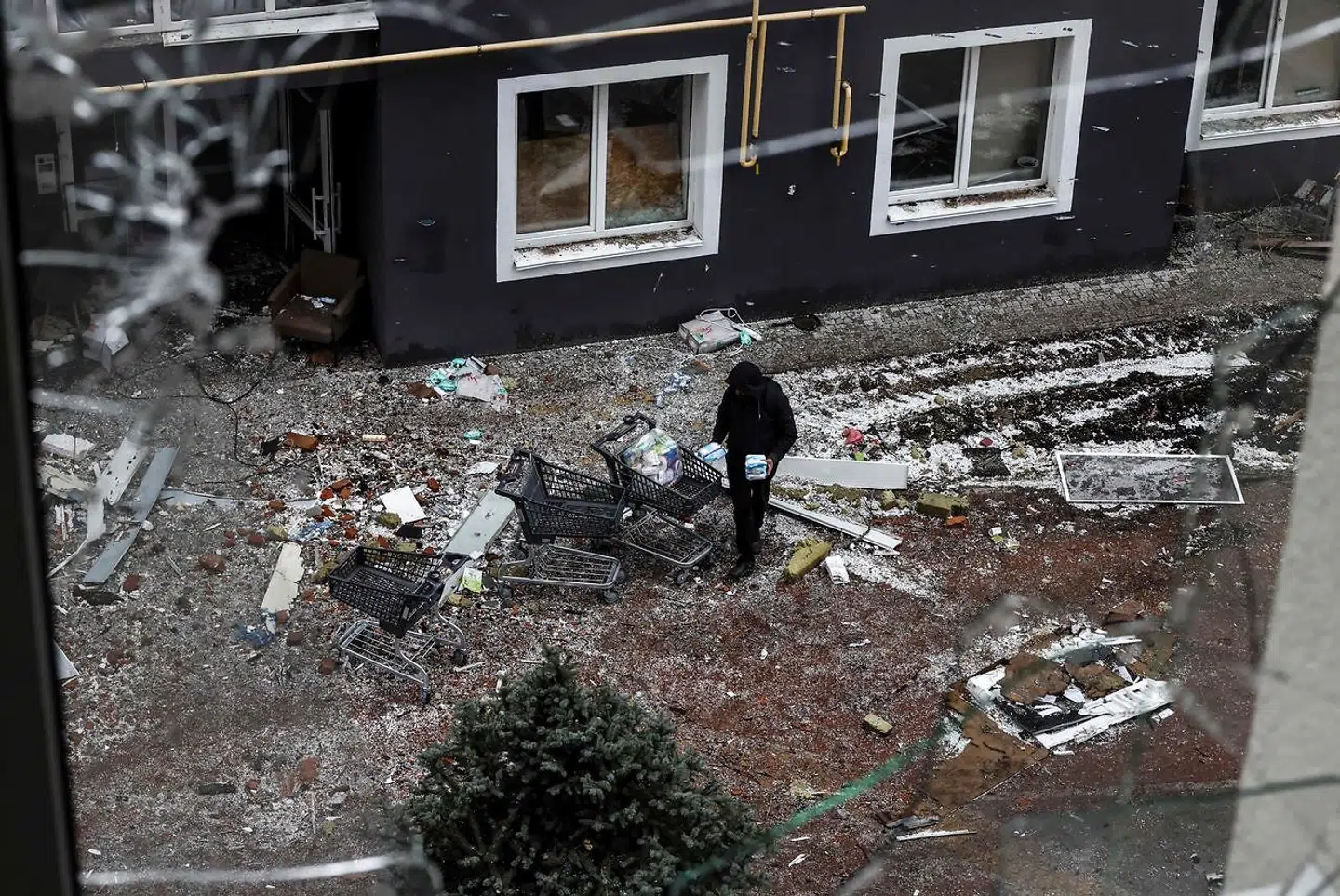 Billedet viser en mand, der leder efter mad i den ødelagte by Bucha.