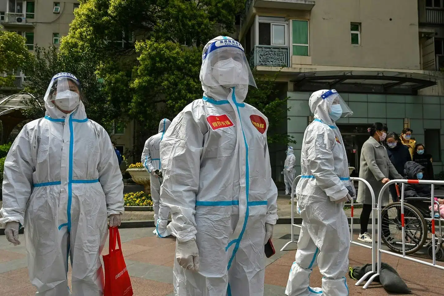 Sundhedsmedarbejdere og frivillige er med til at teste beboere for covid-19-smitte i bydelen Jing i Shanghai. Nu rapporterer Reuters, at myndighederne fjerner smittede børn fra deres forældre.