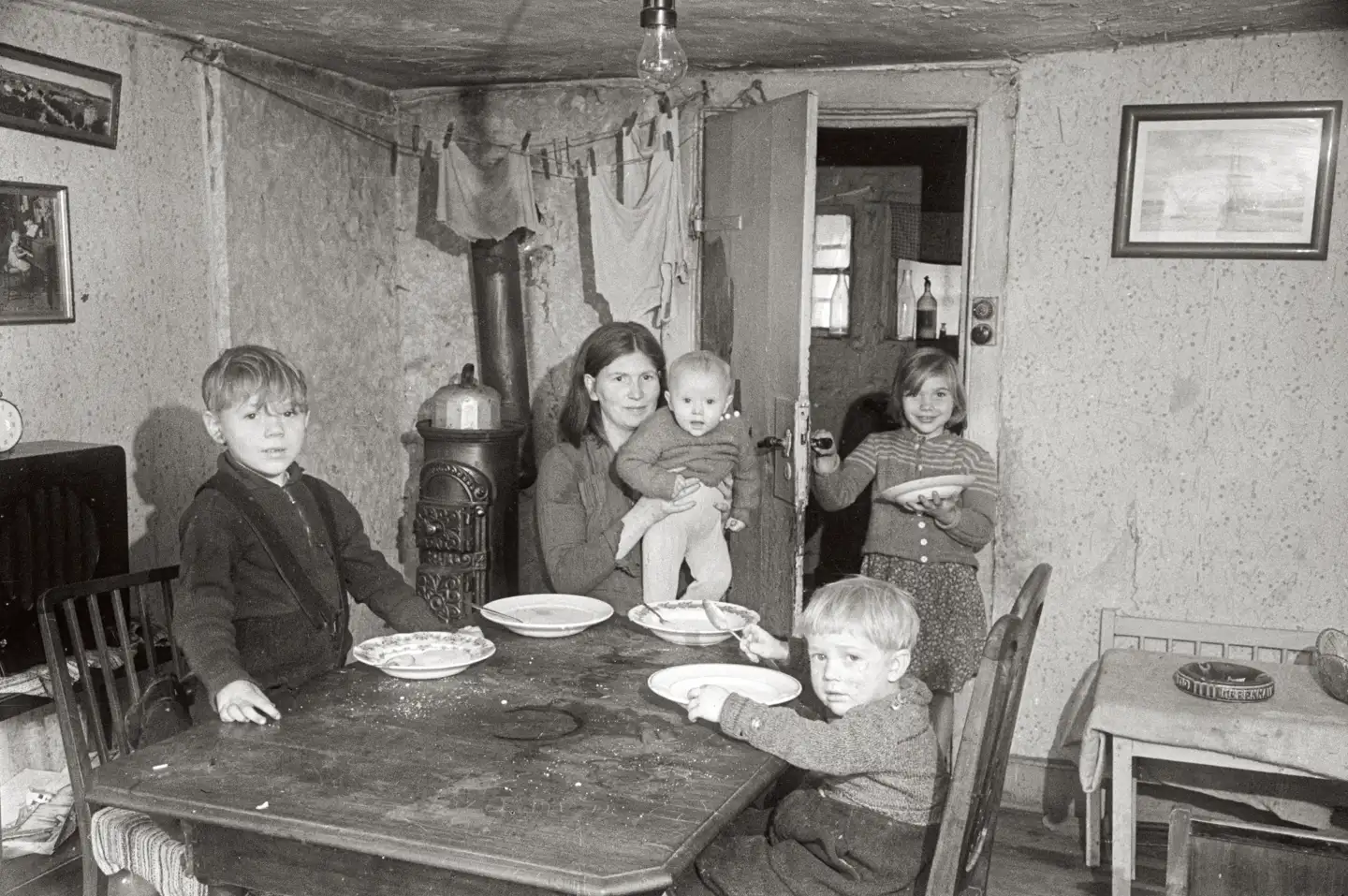 I 1921 boede 120.000 københavnere i overbefolkede lejligheder. I 1965 var det faldet til 25.000. Fotografiet er taget i 1950 med mor og fire børn. Illustration fra bogen.