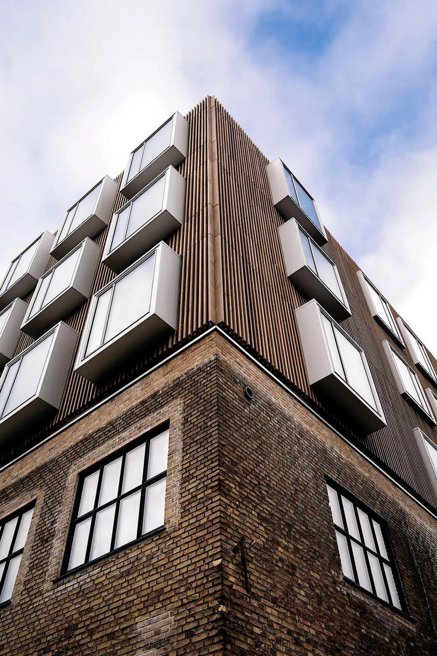 Alukasserne fange himmellyset og skaber dybe vinduesnicher inde i de enkelte boliger.