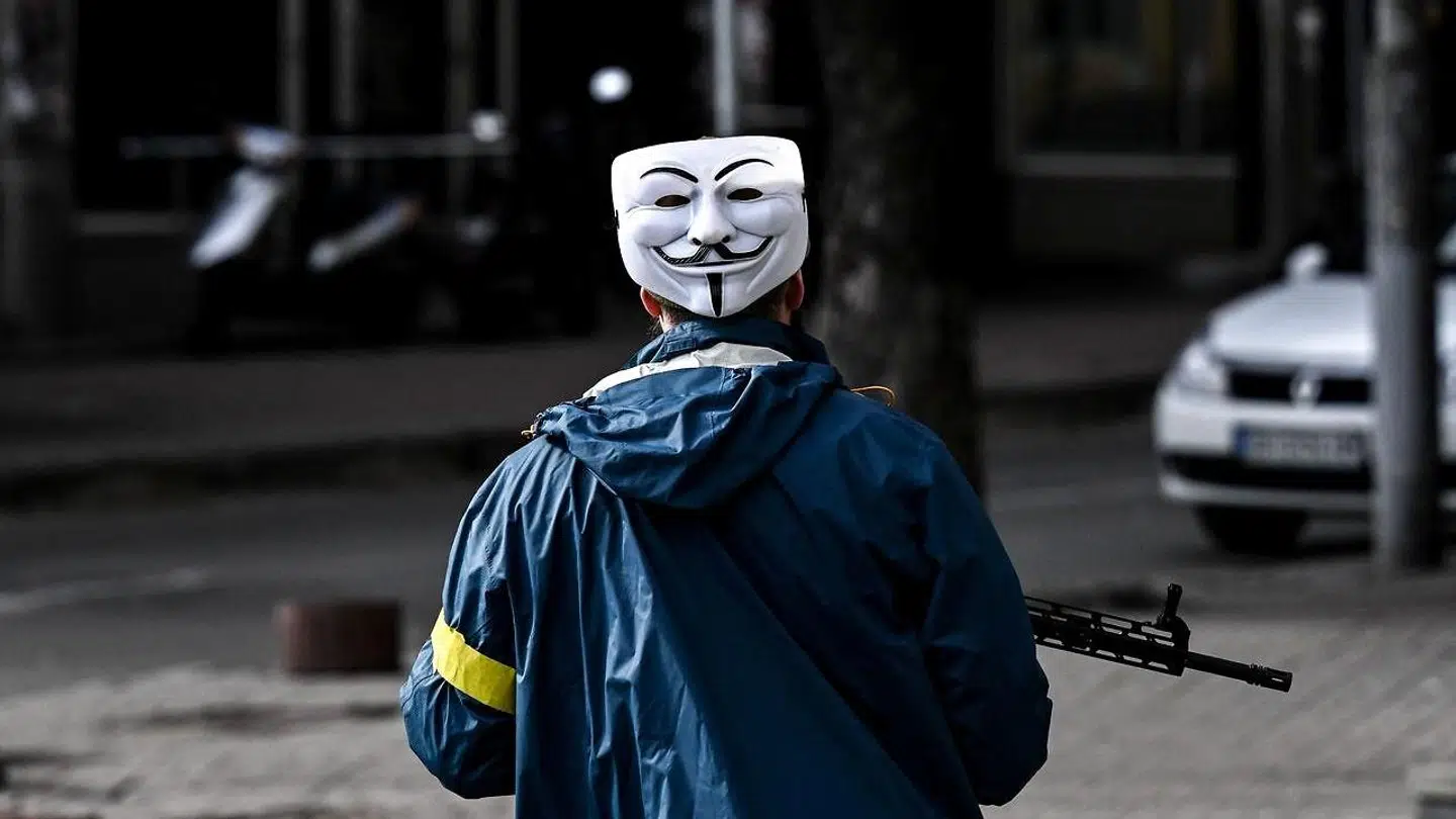 En ukrainsk soldat patruljerer søndag i hovedstaden Kiev godt gemt bag en såkaldt Guy Fawkes-maske, som er blevet symbolet for hackergruppen Anonymous, der i weekenden trådte ind i kampen mod Rusland.