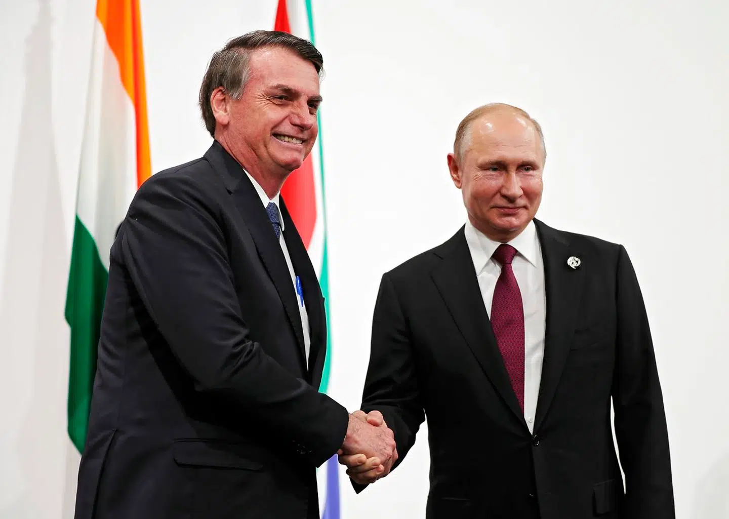 Jair Bolsonaro trykker næve med Vladimir Putin under G-20-møde i 2019. Den brasilianske præsident fastholder et venskabelig besøg hos sin russiske kollega trods Ukraine-krisen.