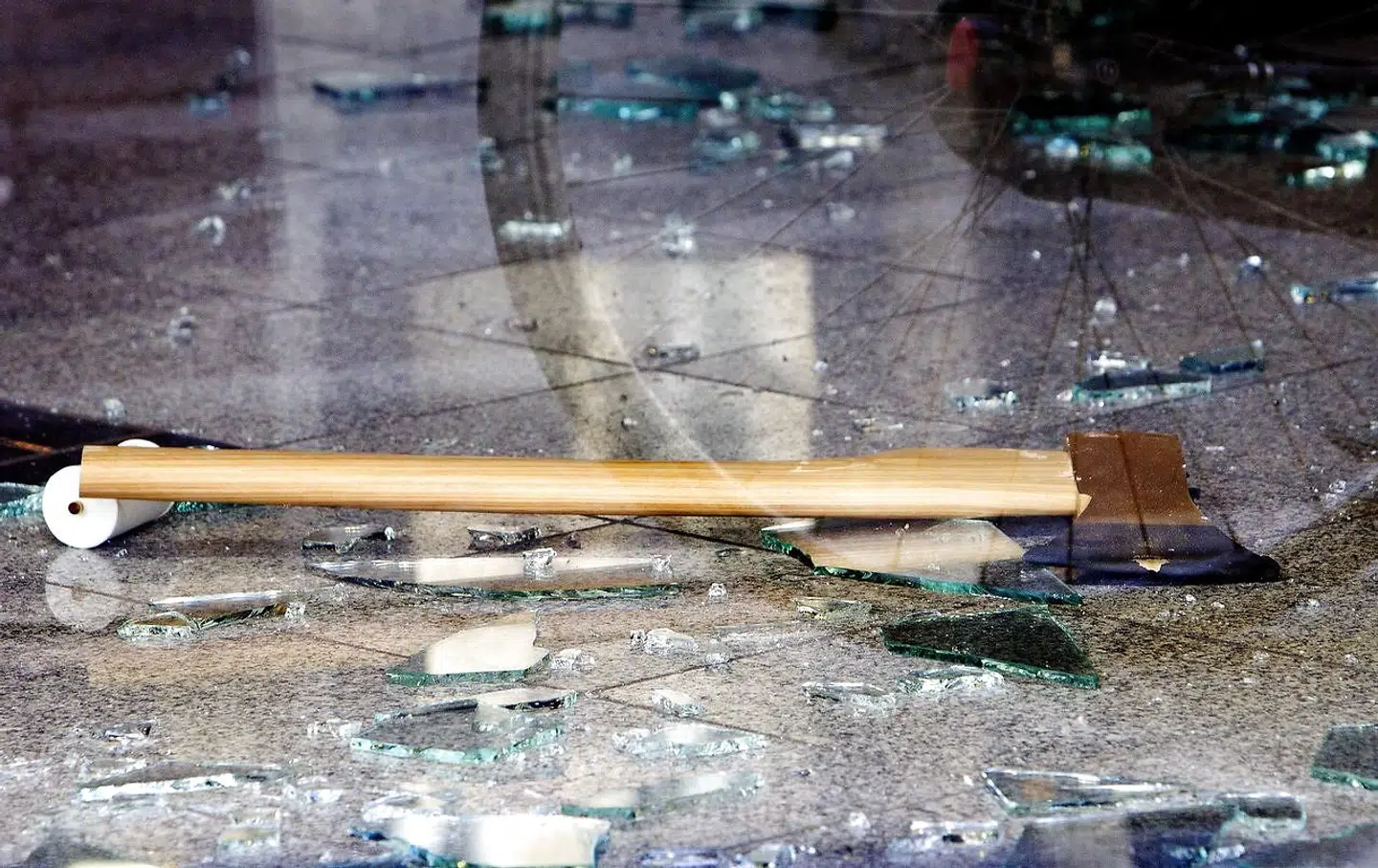 Arkivfoto af en økse ved en smadret rude. Billedet har intet med de nævnte episoder i artiklen at gøre.