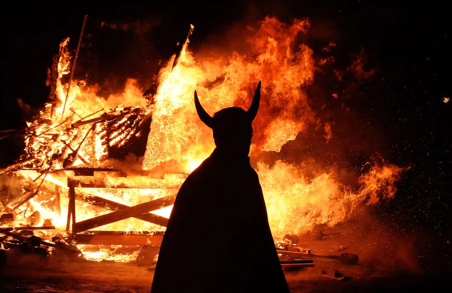 A member of the Viking Jarl Squad is silhouetted in front of a burning viking galley ship during the annual Up Helly Aa Festival, Lerwick, Shetland Islands, on January 26, 2010. Up Helly Aa celebrates the influence of the Scandinavian vikings in the Shetland Islands and has employed this theme in the festival since 1870. The event culminates with up to 1000 'guizers' (men in costume) throwing flaming torches into a Viking longship. TOPSHOTS/AFP PHOTO/Carl de Souza