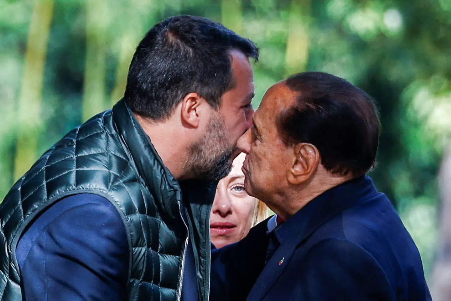 Silvio Berlusconi udveksler kindkys med Lega-lederen Matteo Salvini, mens Giorgia Meloni fra Fratelli d'Italia ser til. Il Cavalieres højrenationale alliancepartnere får ham til at fremstå som en centrumdemokrat.