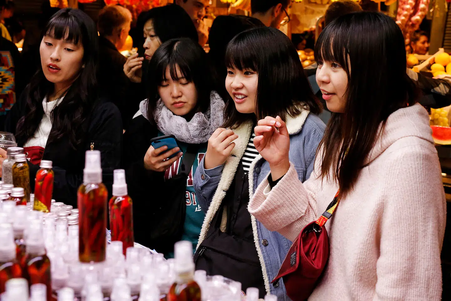 En gruppe japanske kvinder på indkøb blandt boderne i Barcelonas fødevaremarked, La Boquería. Besøgende fra det asiatiske land lægger i gennemsnit tre gange så mange penge i byen som andre internationale turister.