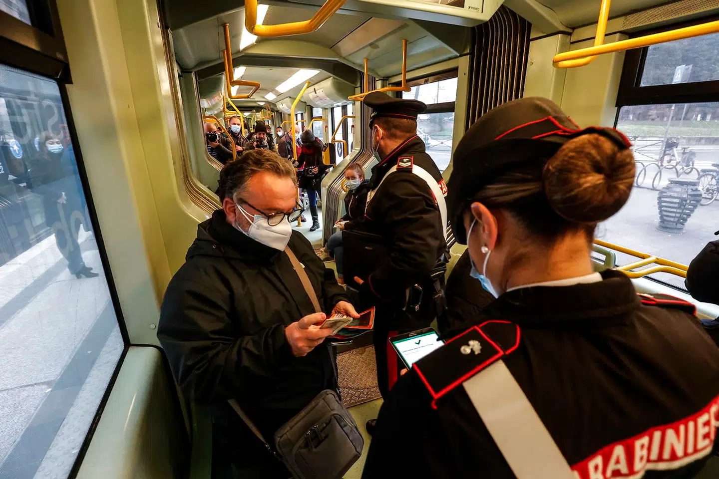 Italienske carabinieri-betjente tjekker vaccinepas i en sporvogn i Rom.