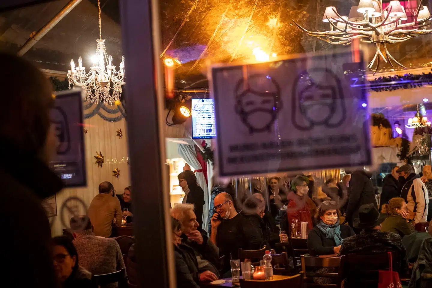 Ingen danskere – bitte. Tyskand har netop sat Danmark på sin liste over højrisikolande. Det betyder, at ikkevaccinerede skal i karantæne i to uger efter indrejse i Tyskland. Her tillader et par tyskere sig – med masker – at nyde livet på en restaurant på julemarkedet ved Gendarmenmarkt i Berlin.