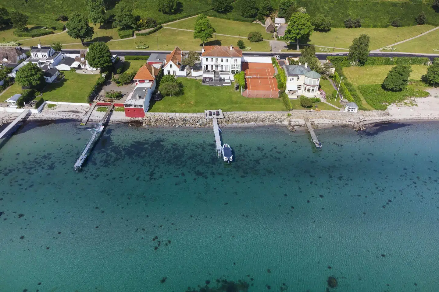 Skodsborg Strandvej 182 med tennisbane og egen badebro blev handlet for 36 millioner kroner i 2017 og er nu solgt igen for 56 millioner kroner. Foto: Elbæks Ejendomsmægler