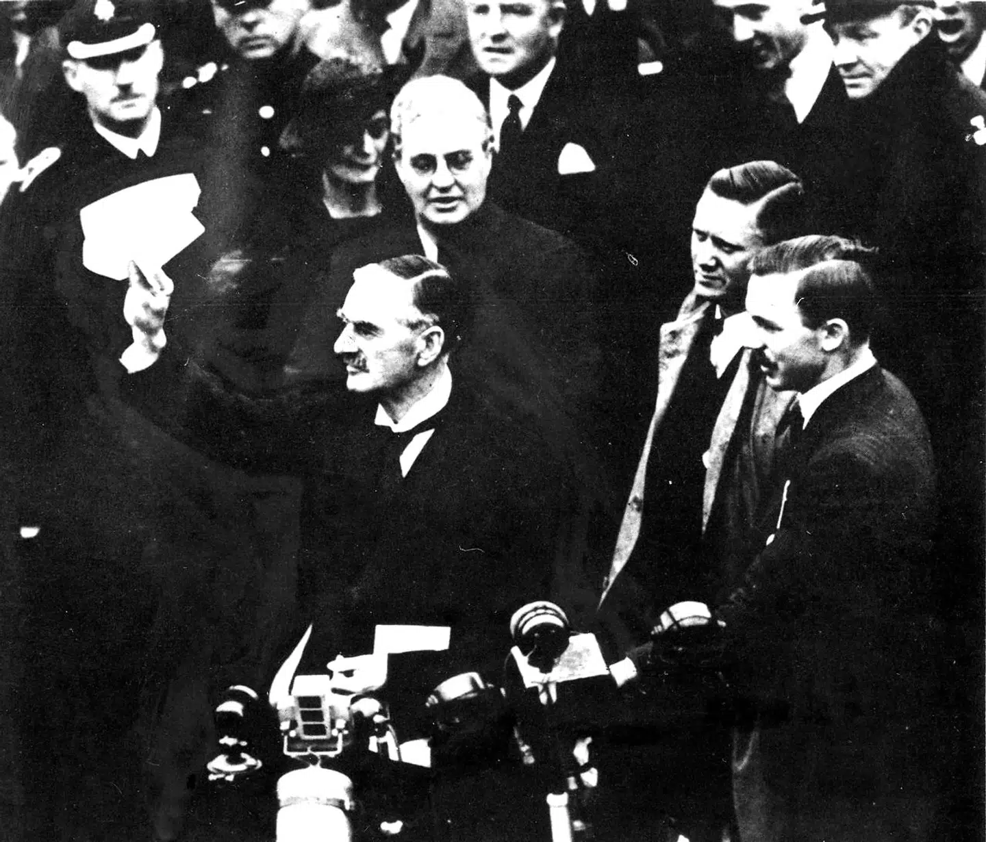 Den britiske premierminister, Neville Chamberlain, kommer hjem til London efter sit møde med Hitler i München i 1938. Han vifter han med den fredsaftale, som han netop har indgået, og udtaler de berømte ord: »Peace in our time«.