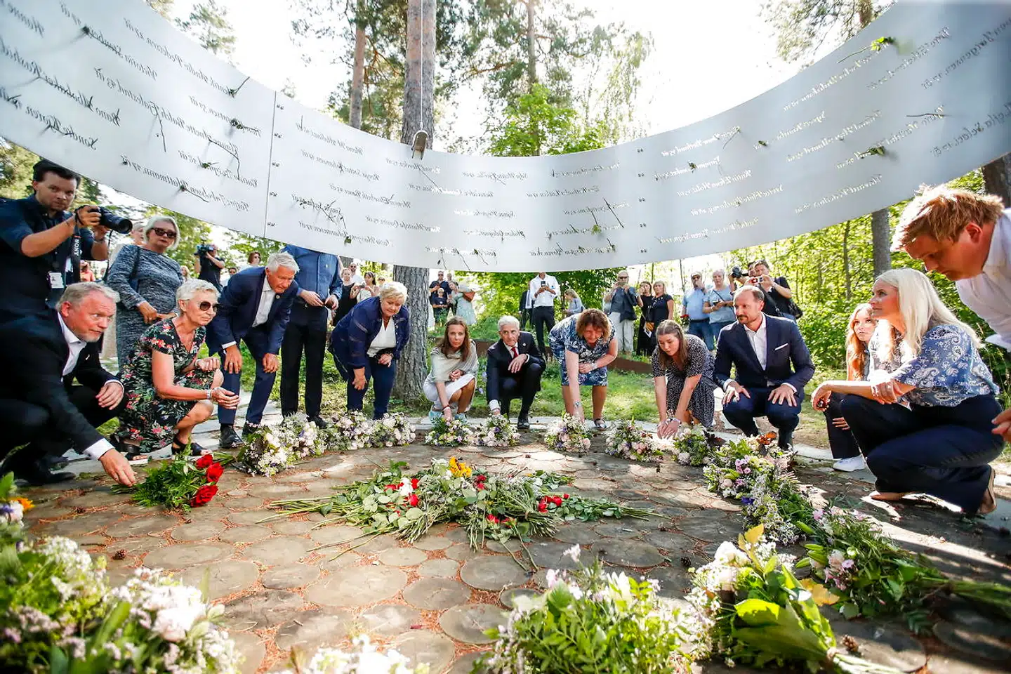 22. juli 2011 dræbte Anders Breivik 69 deltagere i Arbeiderpartiets sommerlejr på Utøya. Ofrene var primært børn og unge. Her ses deltagerne i en mindehøjttidelighed på tiårsdagen i sommer. Lisbeth Røyneland mistede en datter i angrebet og er i dag formand for pårørendestøttegruppen. Hun, der ses i blå storblomstret kjole til højre for midten, har modtaget et brev fra Breivik i fængslet.