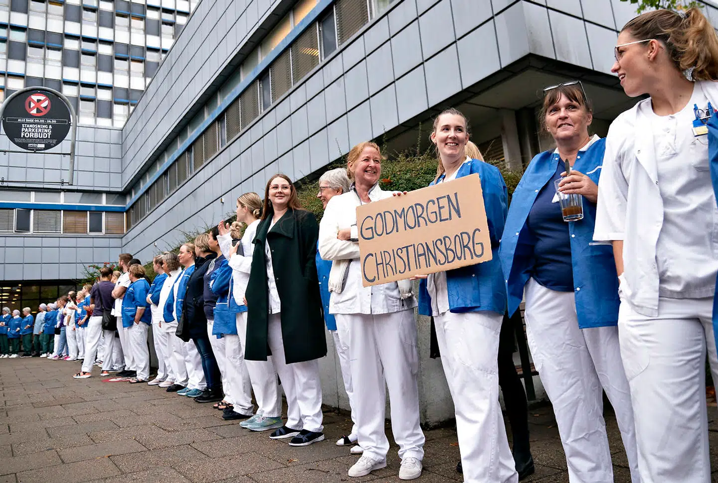 »Selvom velfærdsuddannelserne som sagt er de mest populære blandt de unge, er søgningen vigende. Det er ikke overraskende, når de faglige repræsentanter intet pænt har at sige om deres eget fag,« skriver Amalie Lyhne i denne leder. På billedet ses sygeplejersker på Aalborg Universitetshospital, som har forladt arbejdet og er samlet foran hovedindgangen.