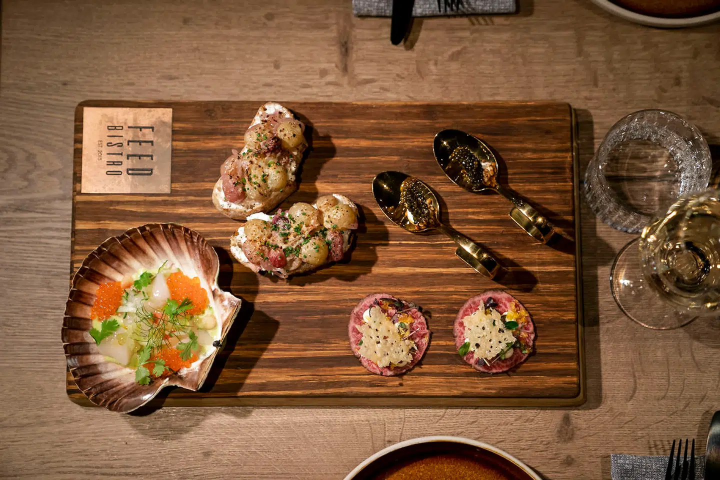 Snackbrættet: Guldskeen, wagyucarpaccio, kammusling og drue-bruschetta.