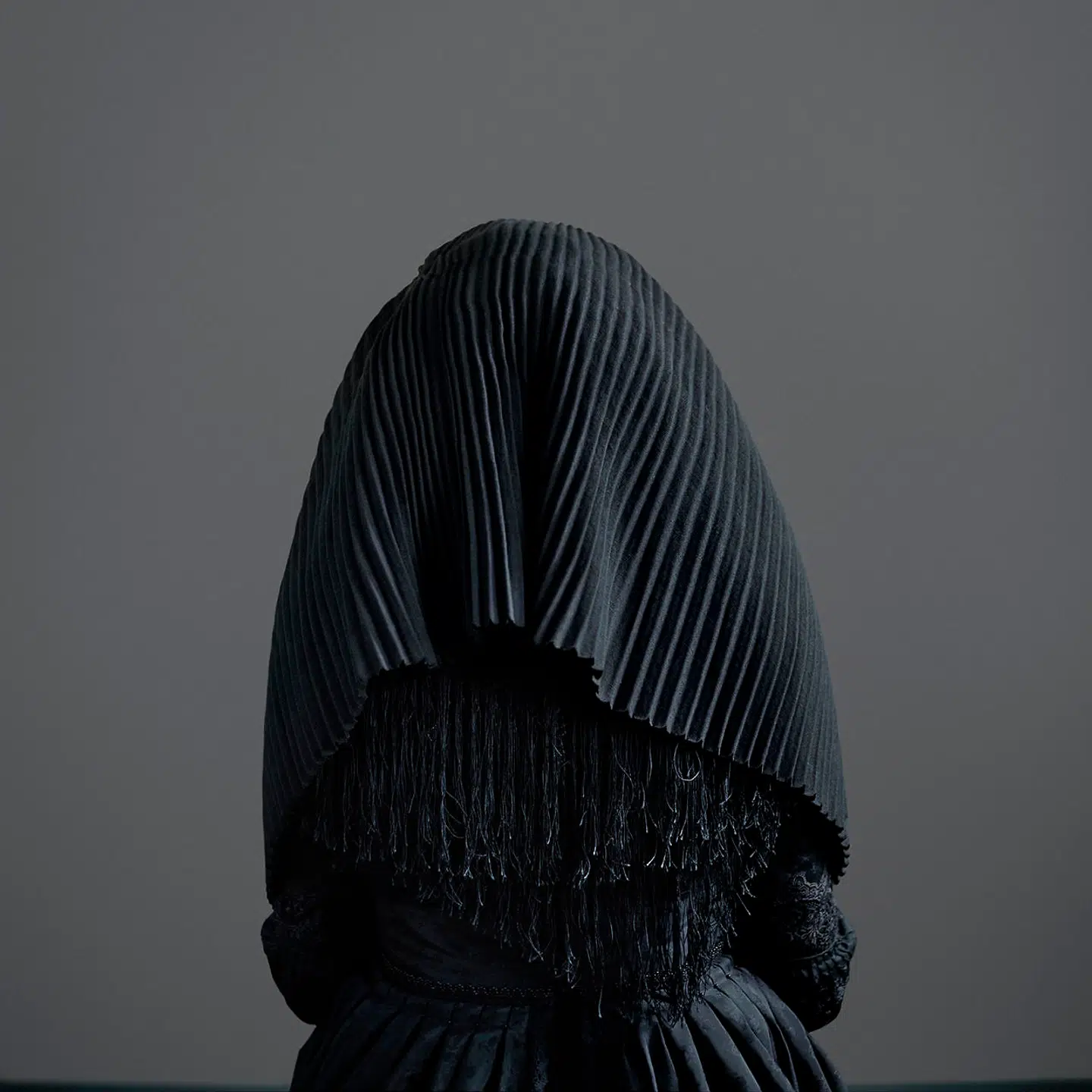 Den forpuppede kvindeskikkelse fra »Surrigkap«-serien er iklædt 1800-tallets sørgedragter, hvor man kun aner konturen af kvinden inde bag ved. Som i flere af Trine Søndergaards værker i udstillingen, hvor historiske hovedbeklædninger fra danske egnsmuseer indgår, er hun her i dialog med tørklædedebatten, men fremmaner samtidig enkle organiske og højæstetiske skulpturer med en hel særlig materialitet at gå på opdagelse i.