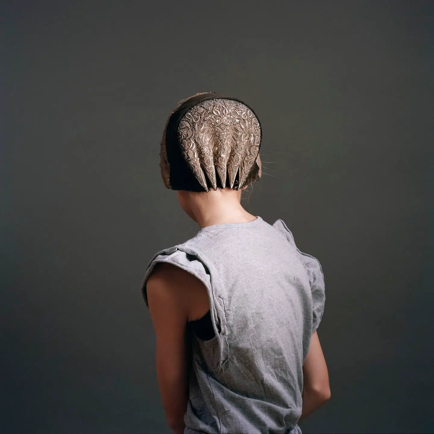 Den rygvendte kvinde med de tydelige referencer til Hammershøi anspores af en tredje tidslighed, hvor datidens folkedragter blendes sammen med moderne beklædningsdele.