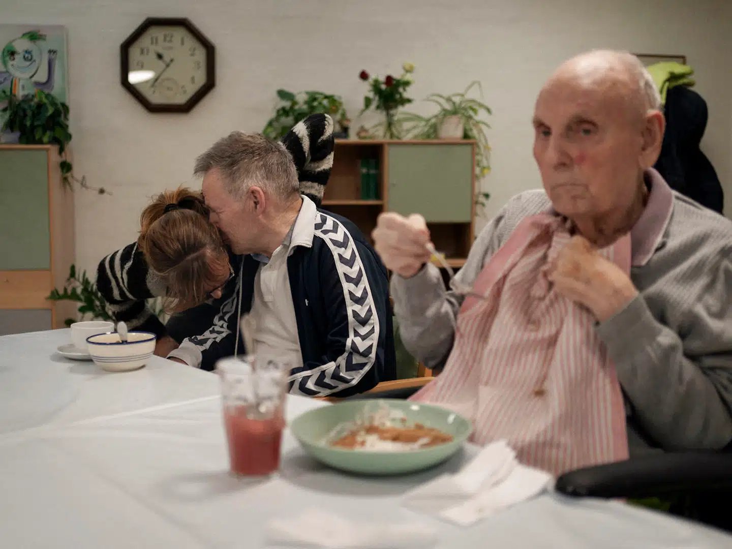 69-årige Ole har Alzheimers og taler ikke så meget længere. Når han gør, er det ofte lavmælt, så personalet må læne sig ind for at høre. Ved siden af Ole er Preben i gang med dagens portion yoghurt med ymerdrys.