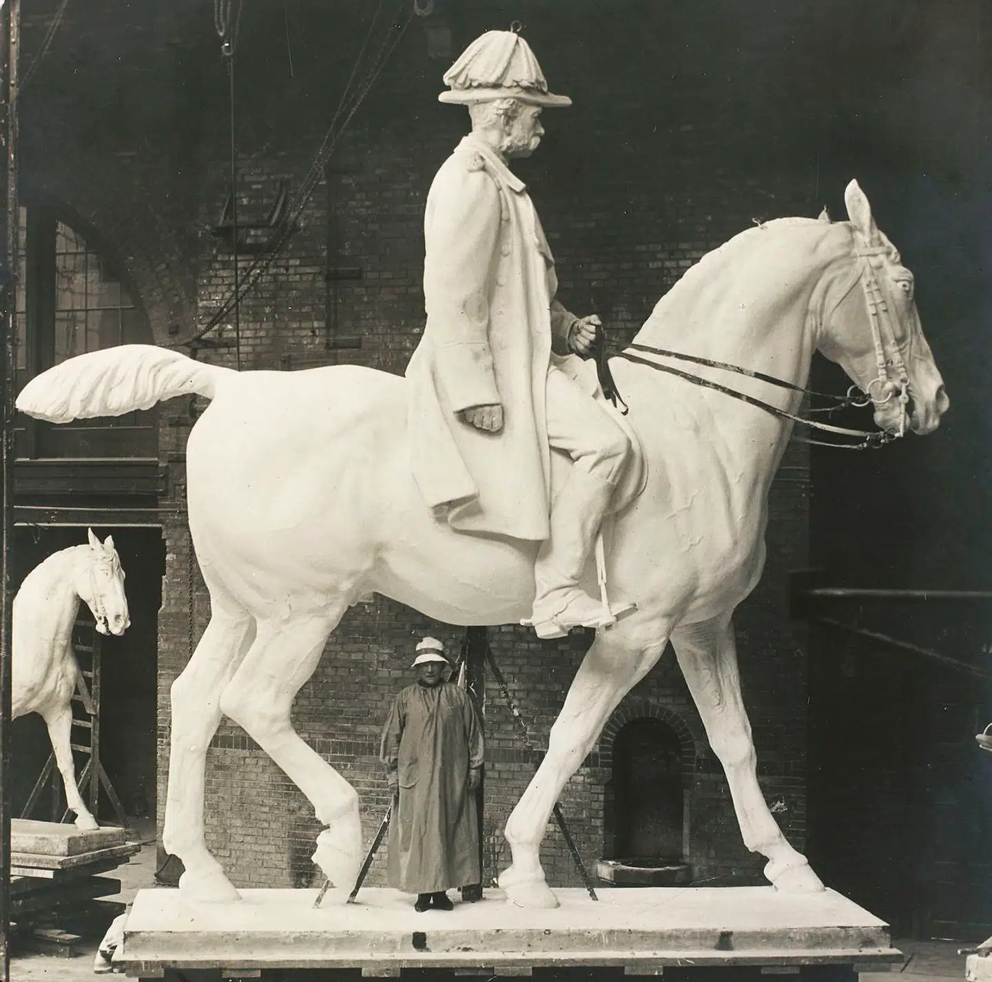 Anne Marie Carl-Nielsen lod sig altid fotografere med sine værker under proces, og derfor er der også masser af billedmateriale på udstillingen at gå på opdagelse i. Hun var kun 155 centimer høj og kunne snildt stå under buen på rytterstatuens hest.