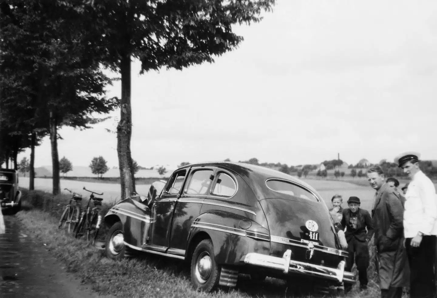 Dronning Ingrid kolliderede med et vejrtræ, da hun tabte kontrollen over sin bil. Her tager nysgerrige forbipasserende ulykkesstedet i øjesyn.